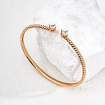 Rose gold bracelet on a textured white surface