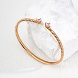 Rose gold bracelet on a textured white surface