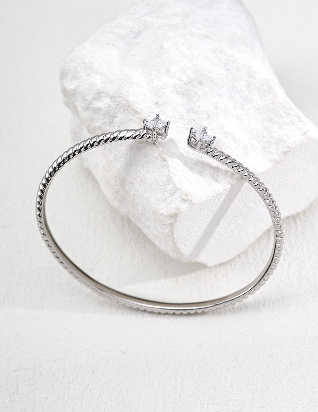 Silver bracelet with star-shaped clasps on a white background