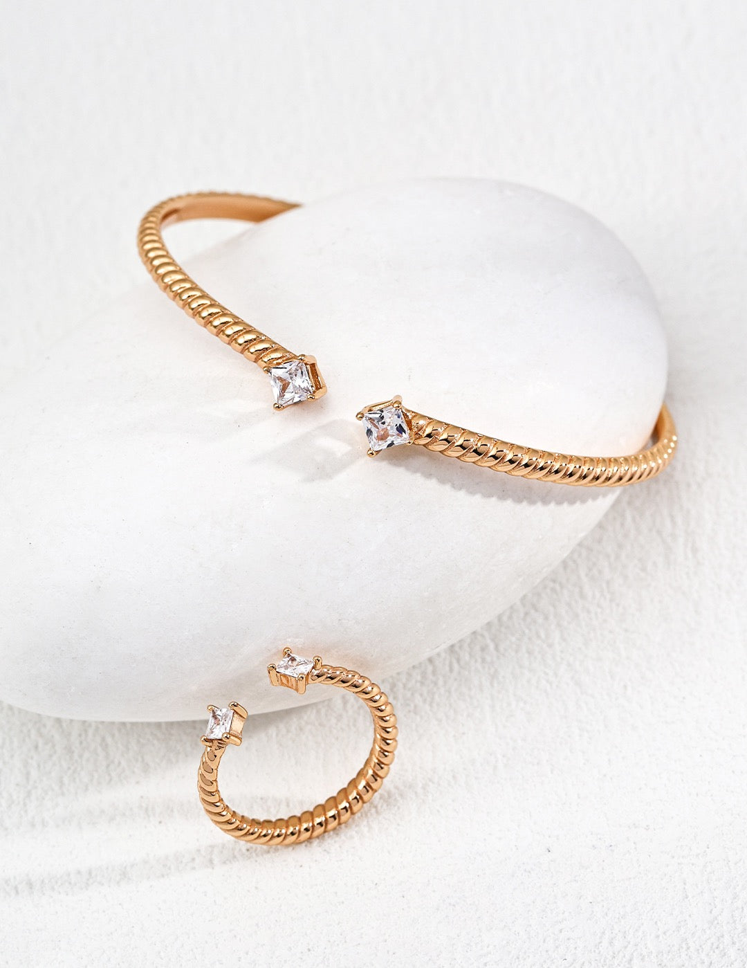 Gold hoop earrings with clear gemstones on a white background