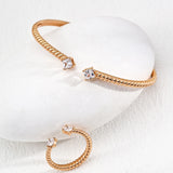 Gold hoop earrings with clear gemstones on a white background