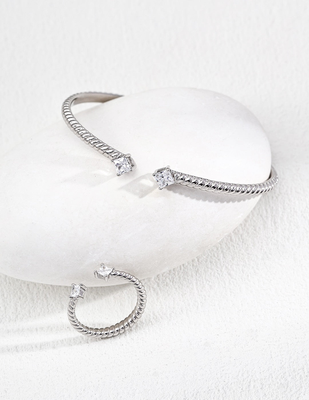 silver bracelets on a light gray background