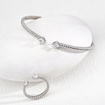 silver bracelets on a light gray background