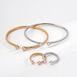 Two gold and silver bracelets on a light gray background