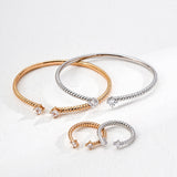 Two gold and silver bracelets on a light gray background