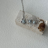 Silver earrings with blue stones on a white stone surface against a light gray background