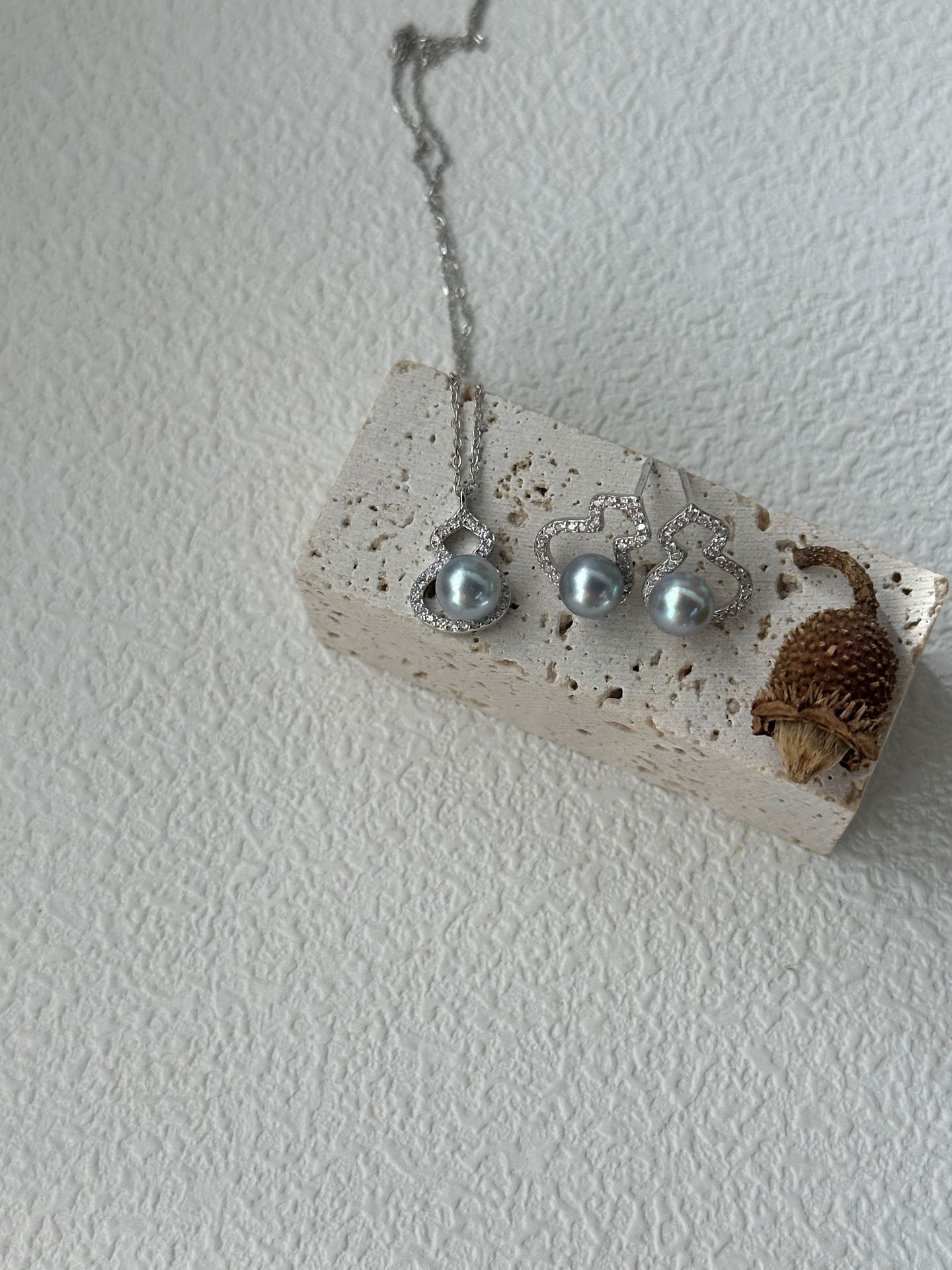 Silver earrings with blue stones on a white stone surface against a light gray background