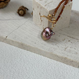 Pearl earring on a white surface with a small decorative block