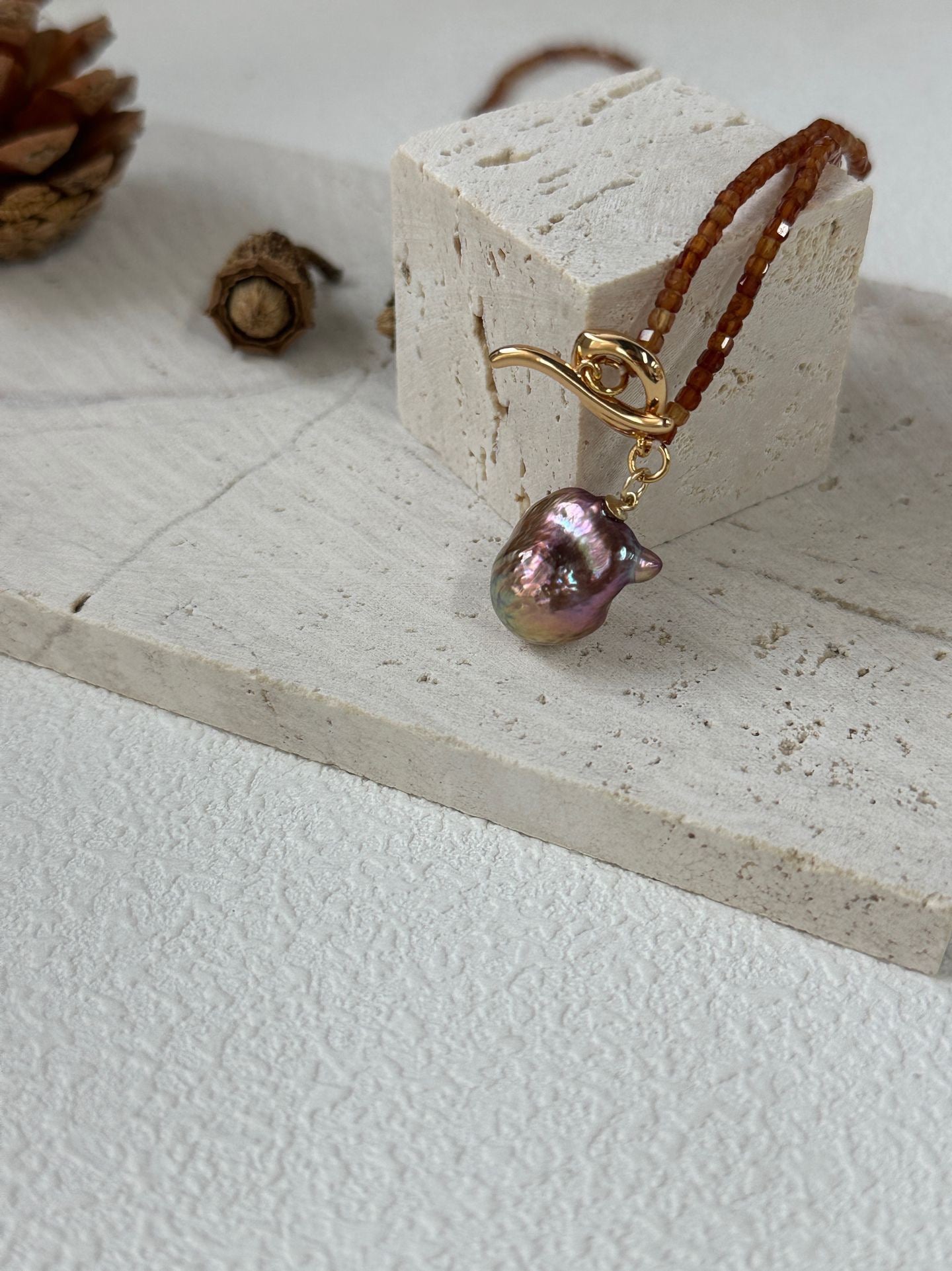 Pearl earring on a white surface with a small decorative block