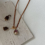 Necklace with a pendant on a textured surface