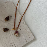 Necklace with a pendant on a textured surface