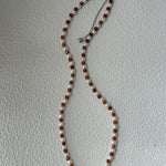 Necklace with brown and white beads on a light gray background