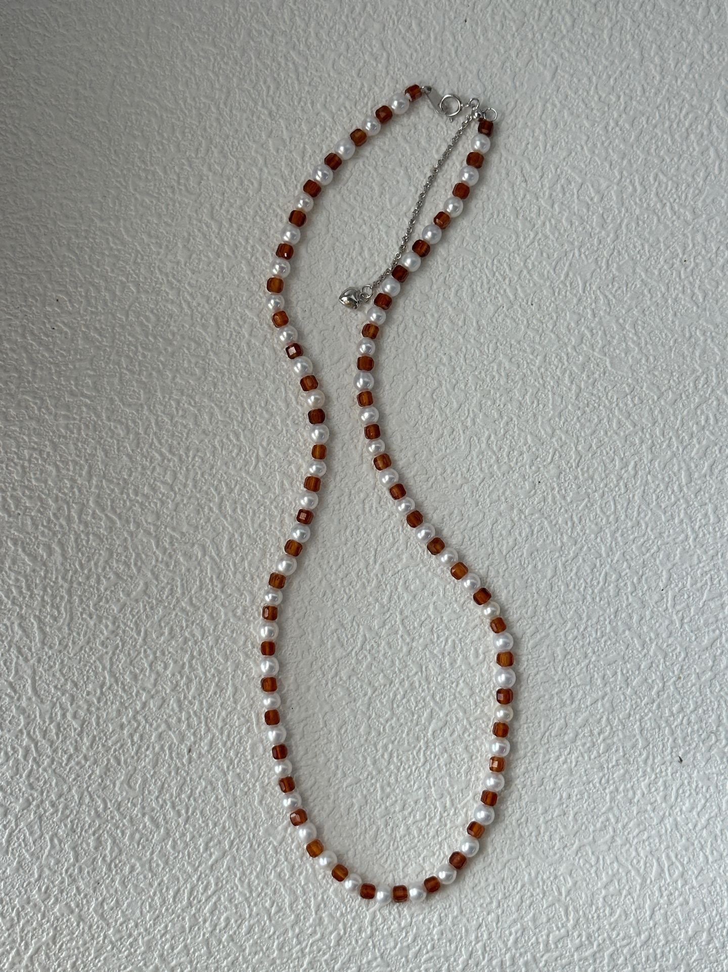 Necklace with brown and white beads on a light gray background