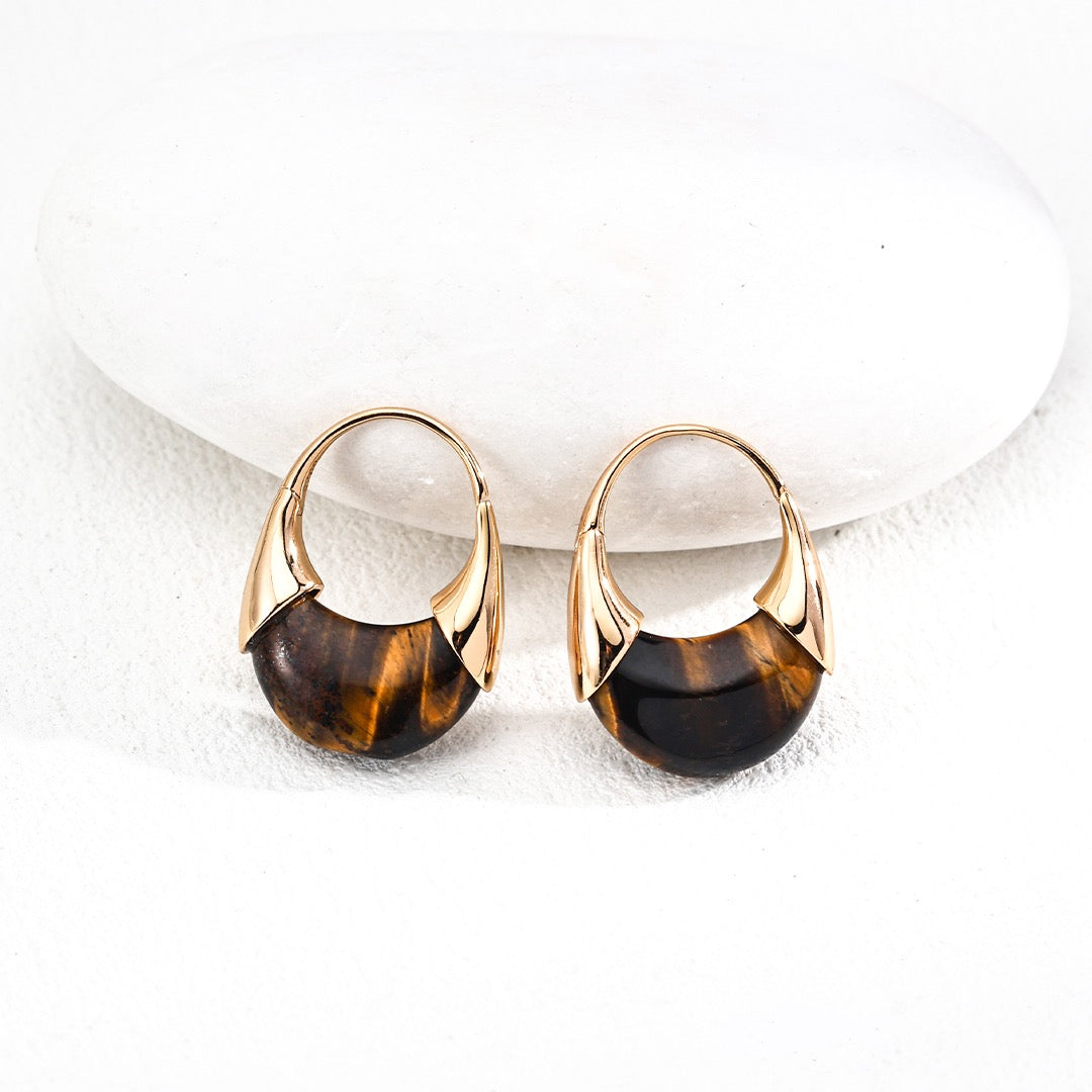Pair of gold and black earrings on a white background