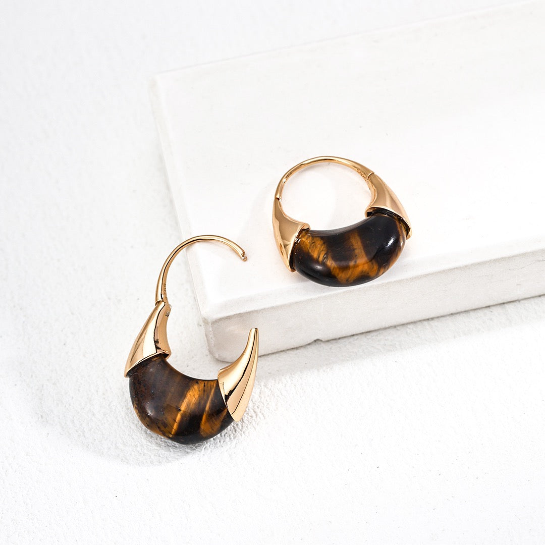 Pair of tortoiseshell hoop earrings on a white surface