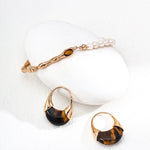 Gold jewelry set with tiger eye stones on a white background