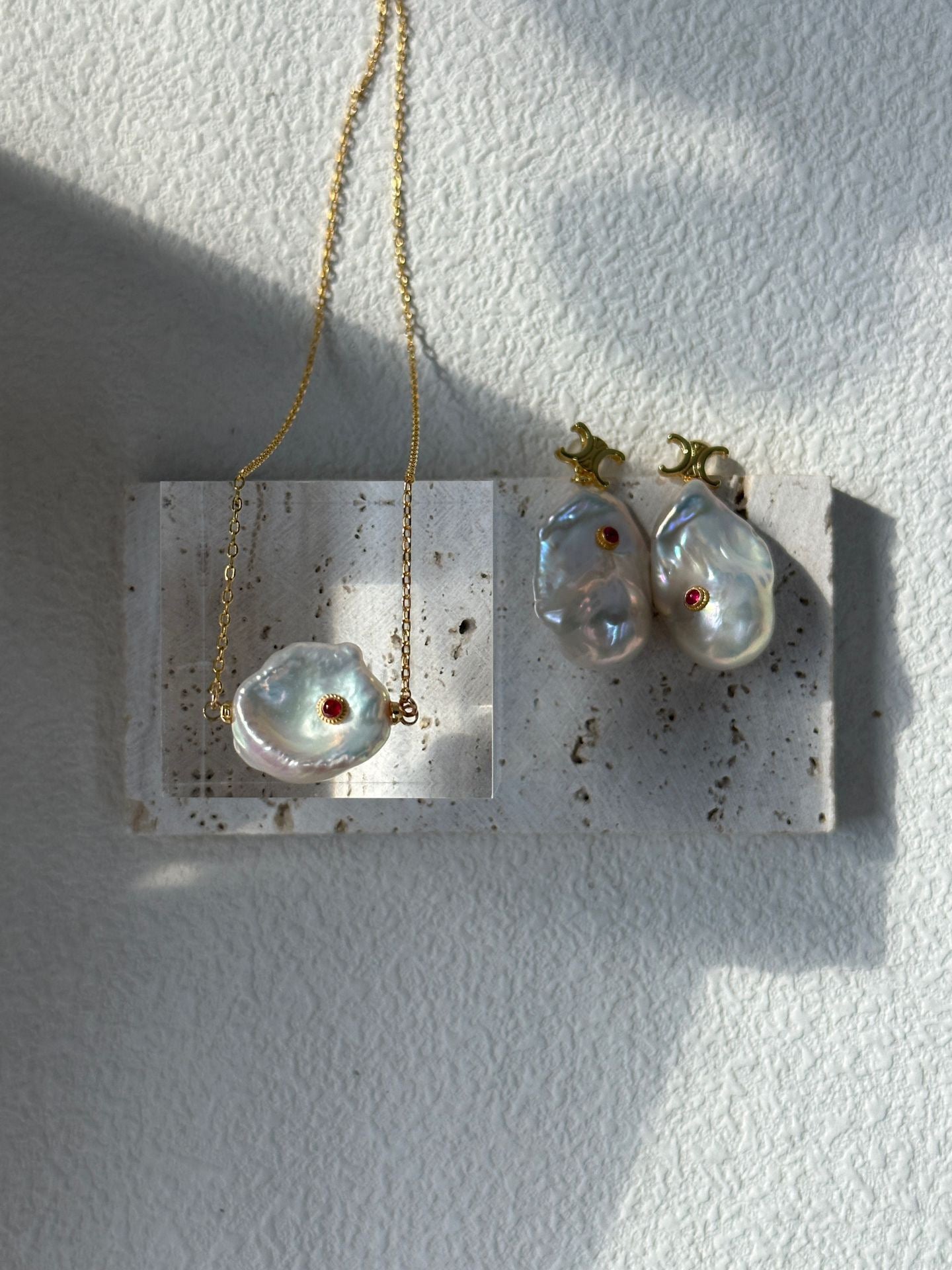 Jewelry display with two pendants on a white background