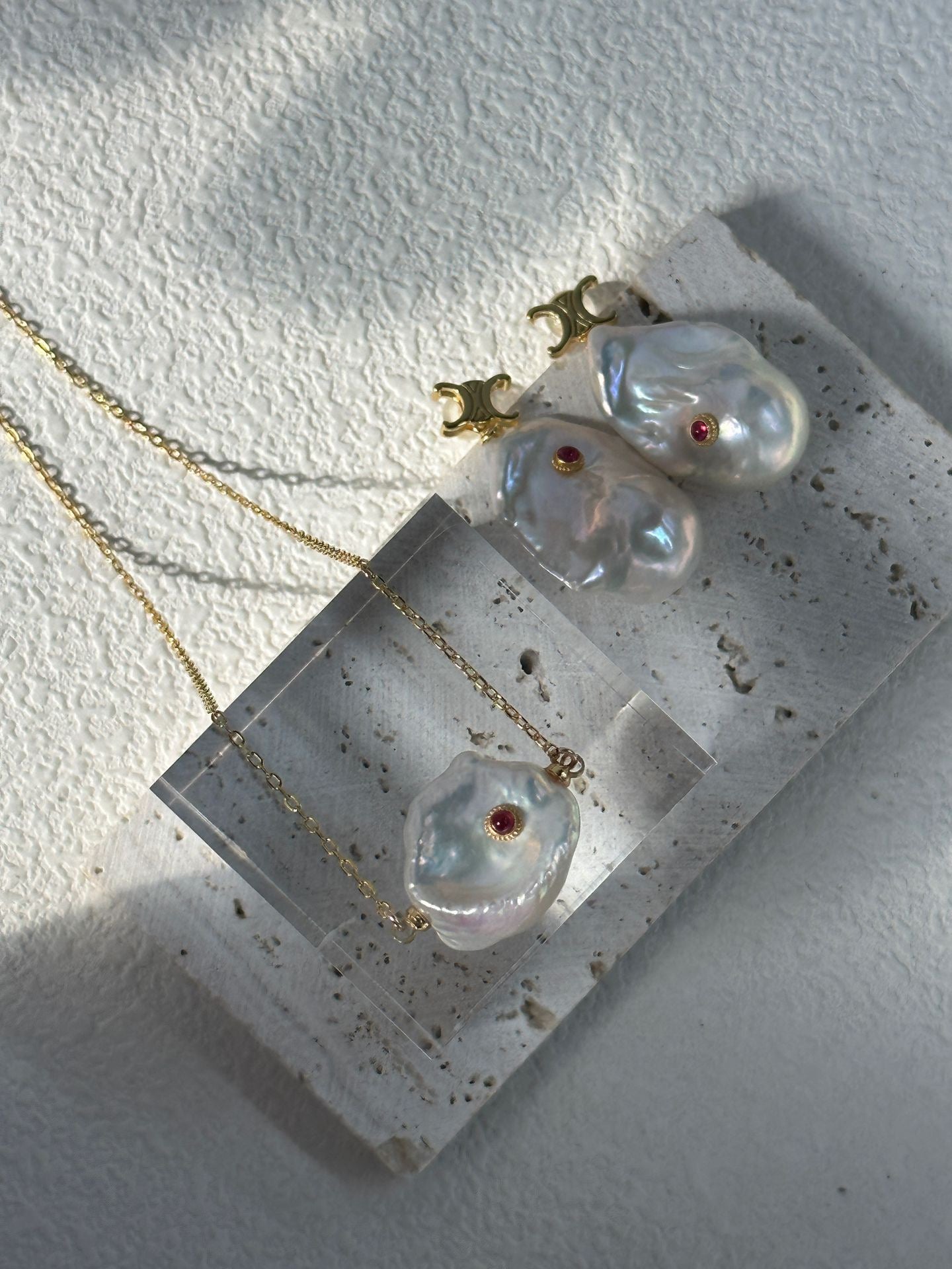 Pearl jewelry set with necklace and earrings on a concrete block