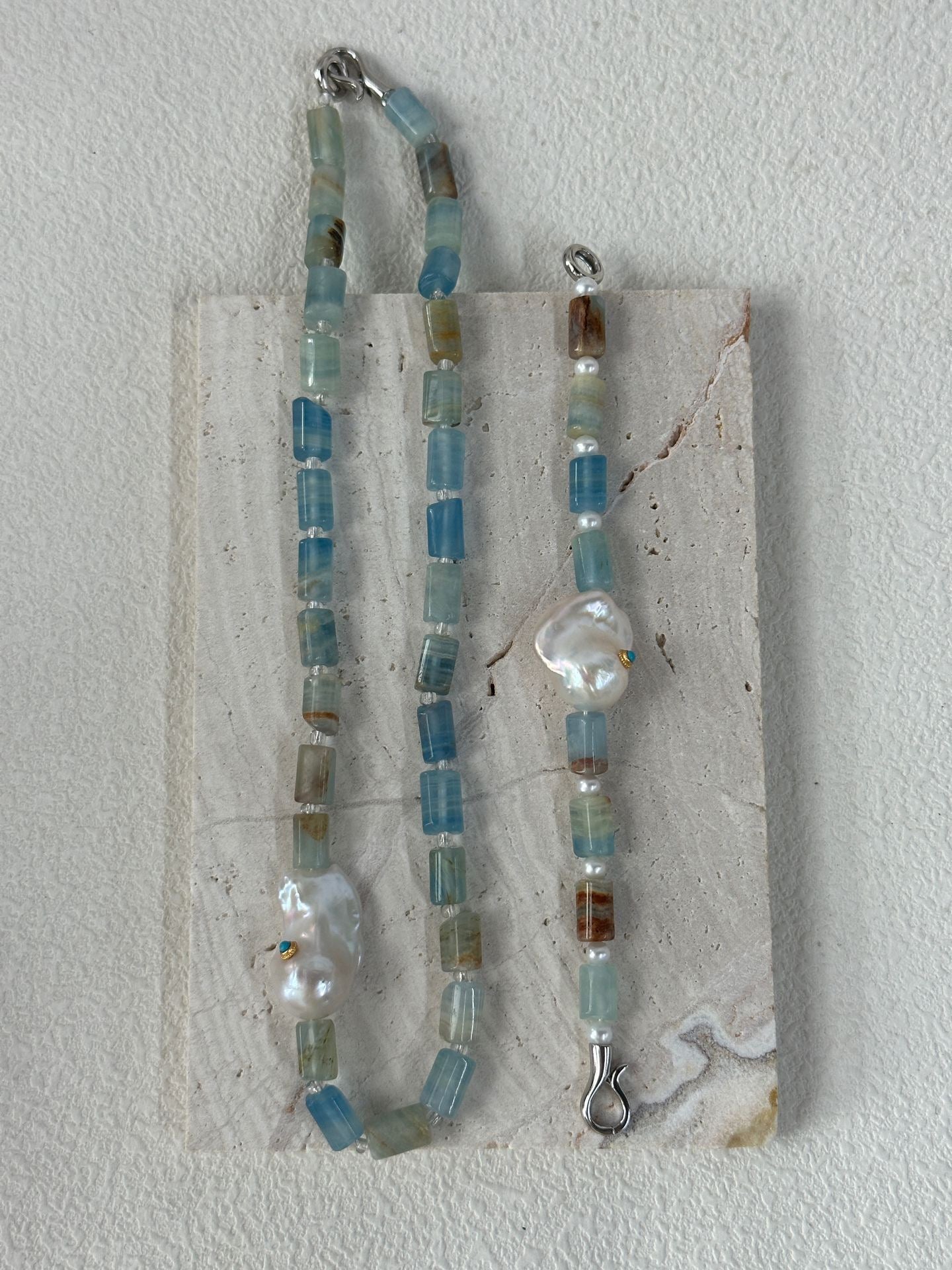 Necklace with blue and silver beads on a white background