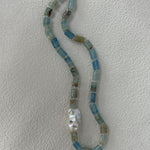 Necklace with blue and silver beads on a white background
