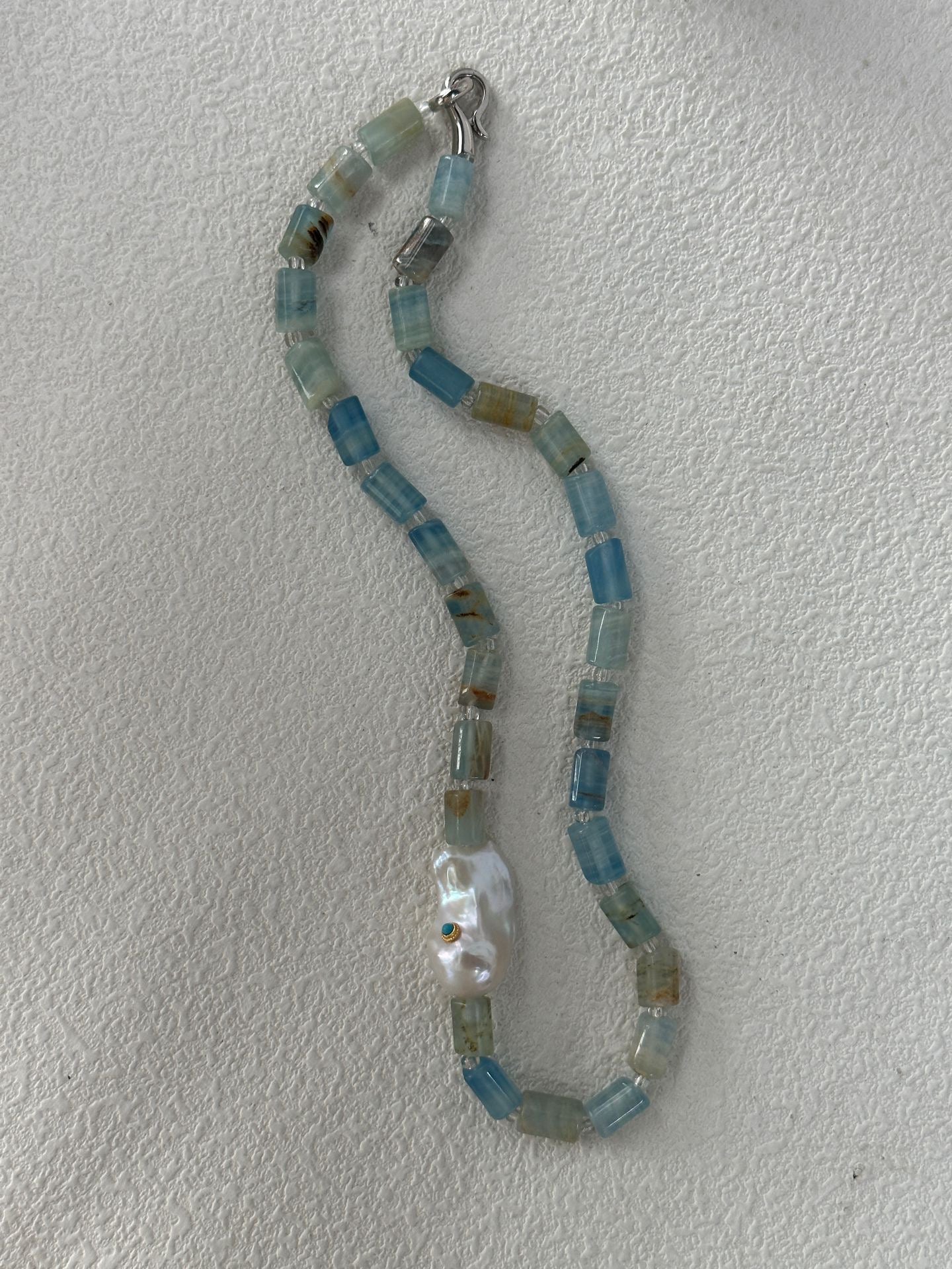 Necklace with blue and silver beads on a white background