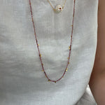 Necklace with small beads on a plain background