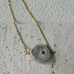 Necklace with a large, irregularly shaped pendant on a textured surface
