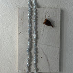 Necklace with blue beads on a textured white surface