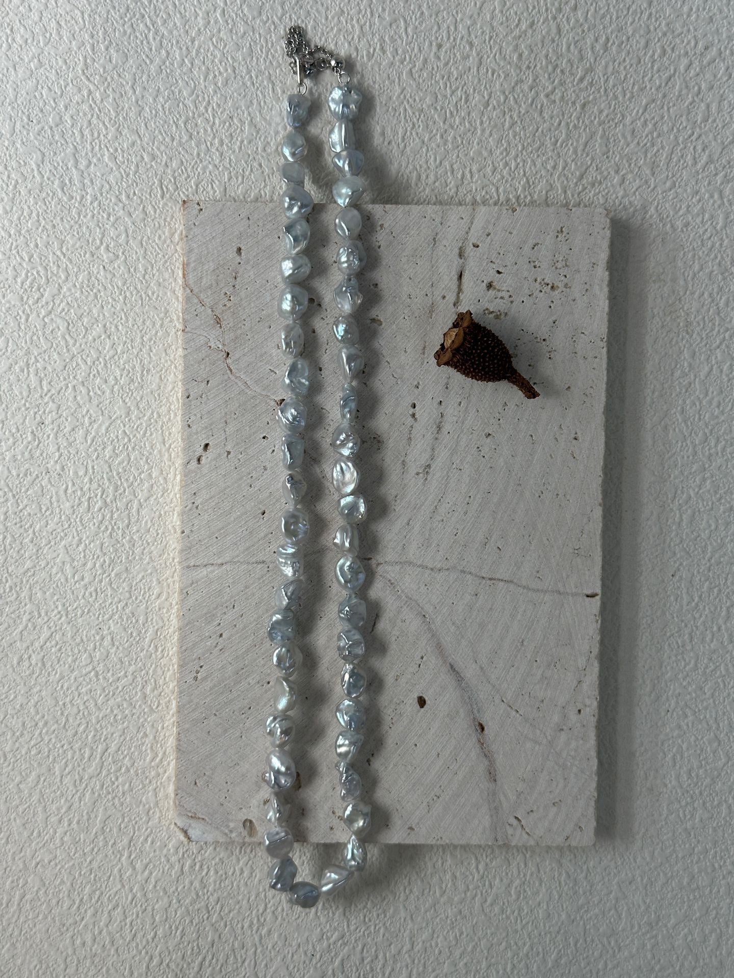 Necklace with blue beads on a textured white surface