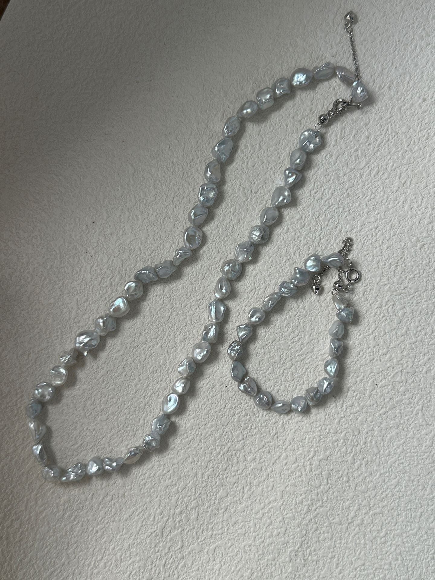 Pearl necklace on a light gray background