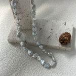 Necklace with clear beads on a textured surface