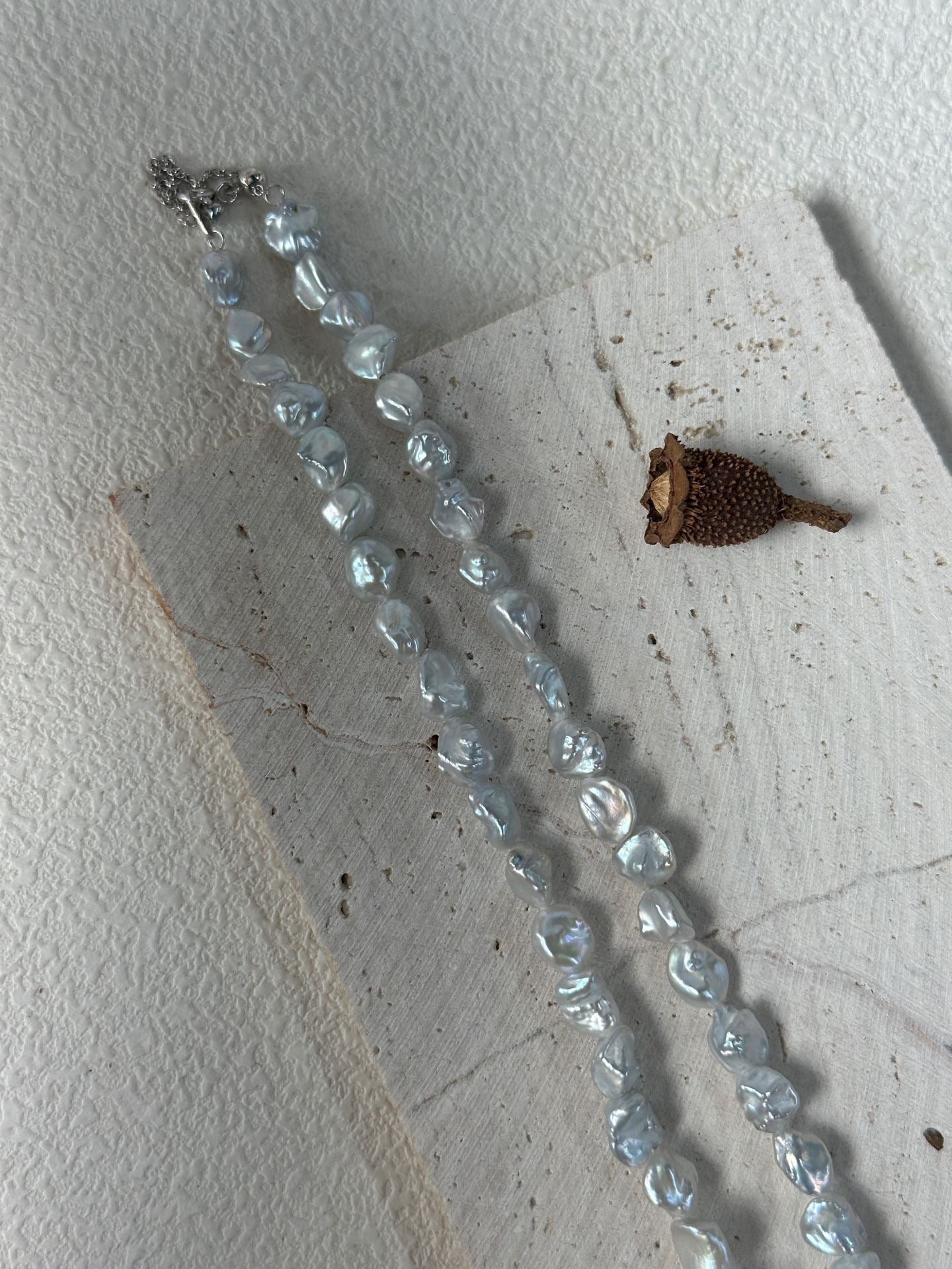 Necklace with blue beads on a textured white surface