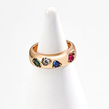 Gold ring with colorful gemstones on a white background