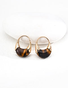 Pair of gold and black earrings on a white background