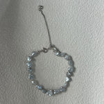 Silver beaded bracelet on a plain background