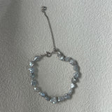 Silver beaded bracelet on a plain background