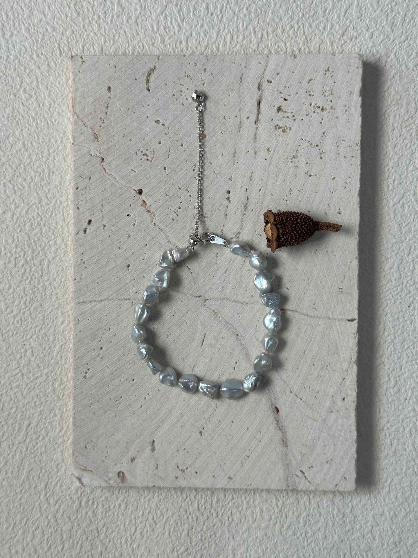 Bracelet with beads and a small decorative item on a textured surface