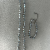 Necklace and bracelet set with clear stones on a light gray background