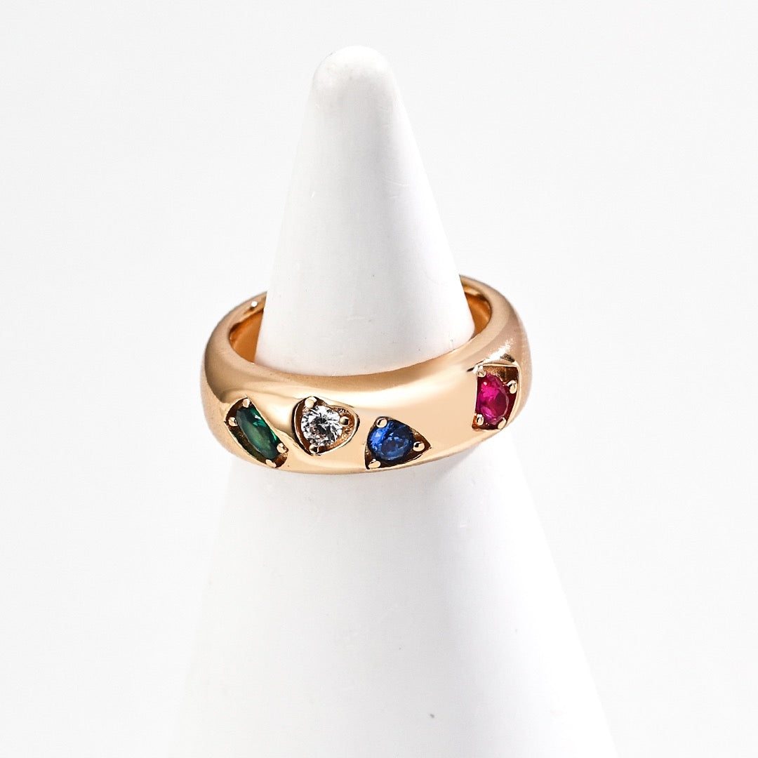 Gold ring with colorful gemstones on a white background