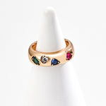 Gold ring with colorful gemstones on a white background