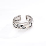 Silver ring with embedded stones on a white background