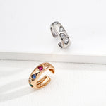 Two rings, one gold and one silver, on a white surface.