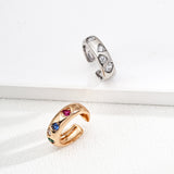 Two rings, one gold and one silver, on a white surface.