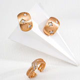 Pair of gold earrings with star designs on a white surface