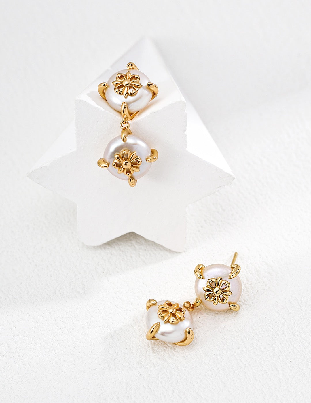 Gold and pearl earrings on a white background