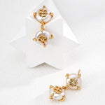 Gold and pearl earrings on a white background