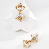 Gold and pearl earrings on a white background
