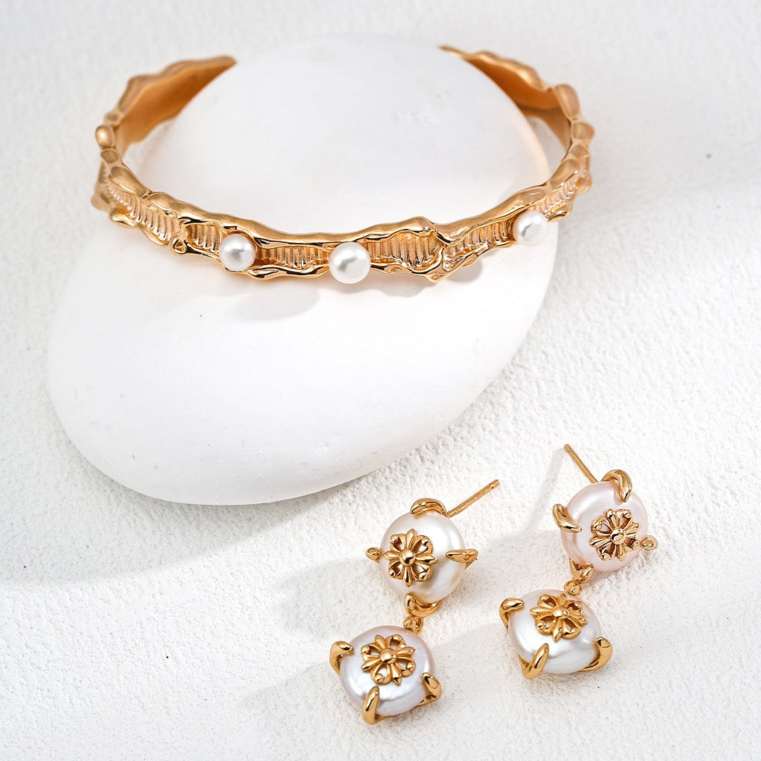 Gold and pearl jewelry set on a white background