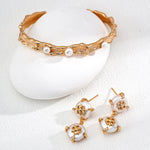 Gold and pearl jewelry set on a white background