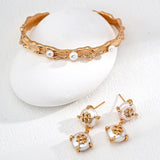 Gold and pearl jewelry set on a white background